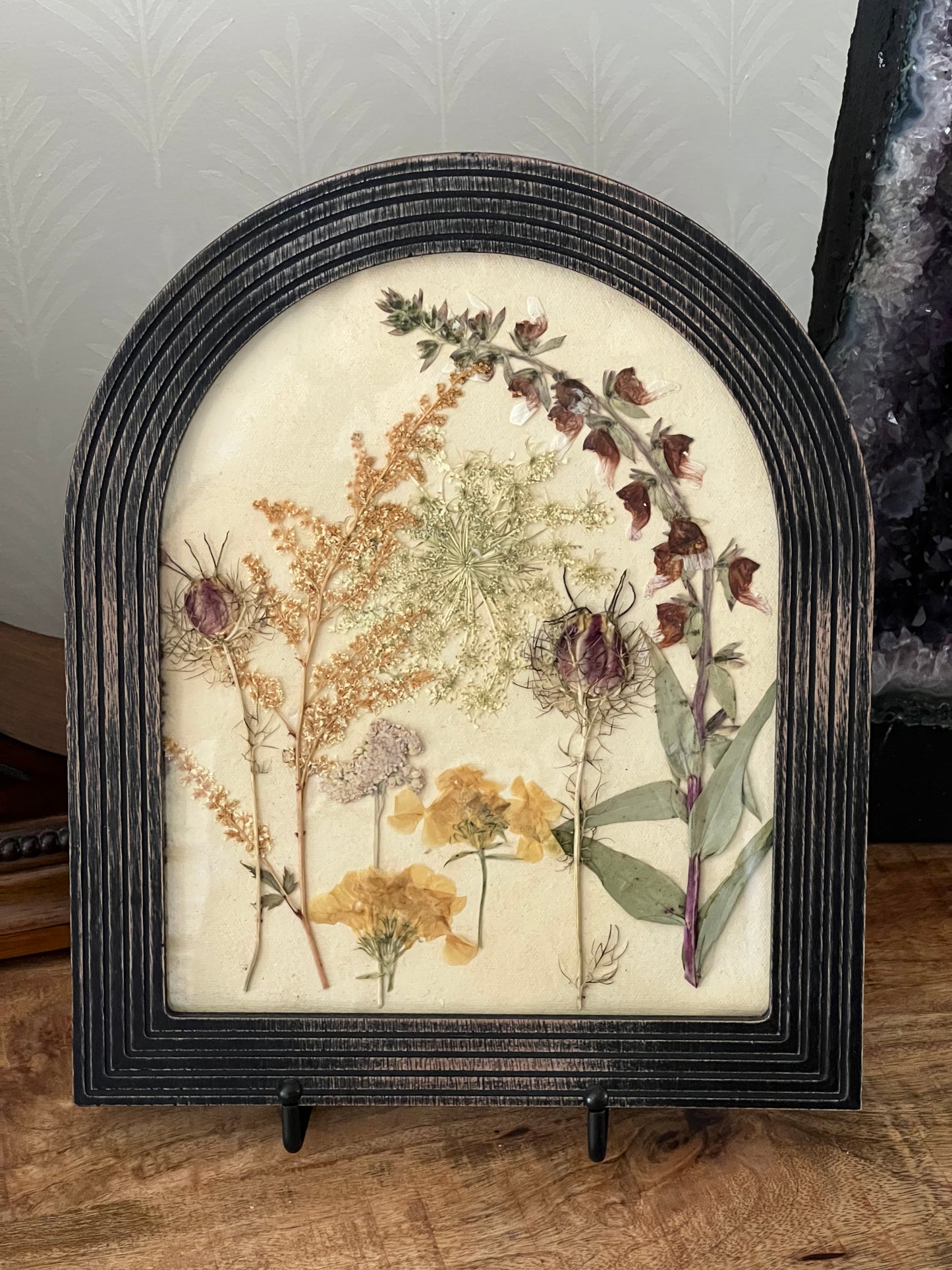 Pressed botanicals in arched wood frame